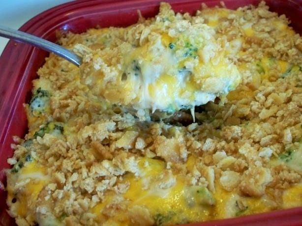 a casserole dish with broccoli and cheese being lifted from the casserole