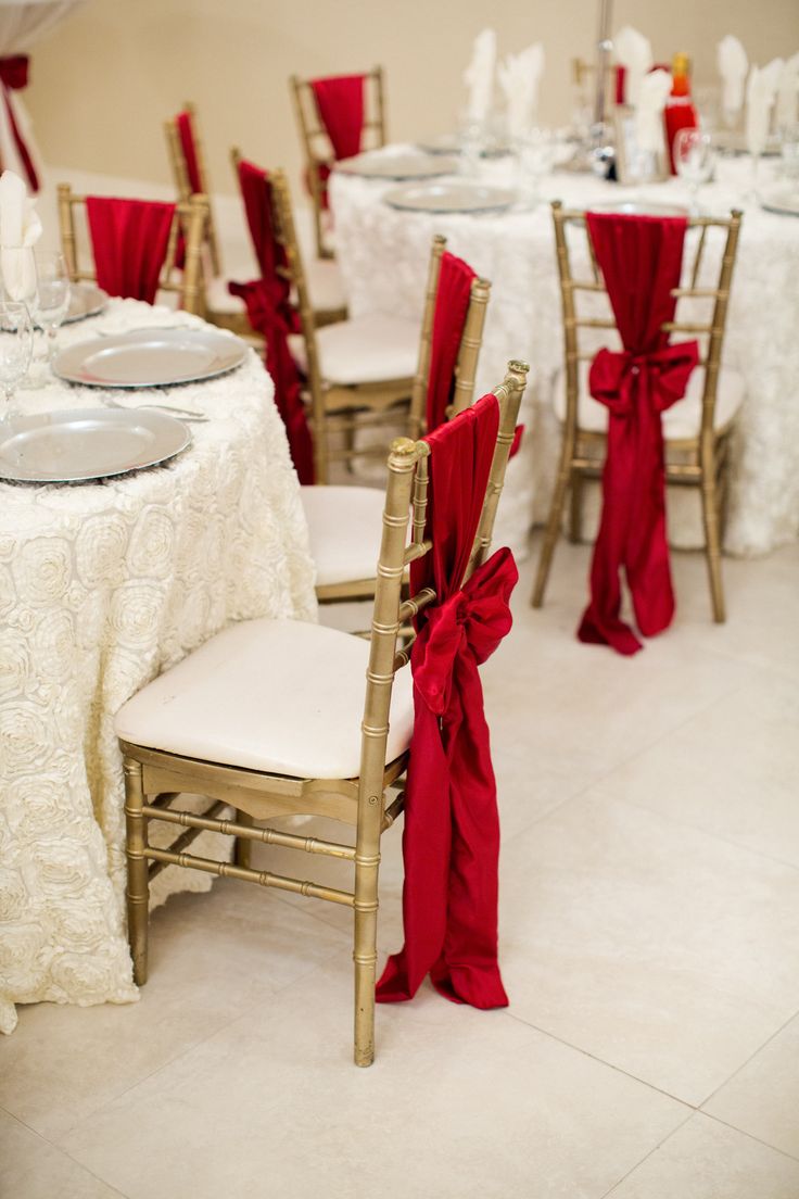 the tables are set with white linens and red sashes