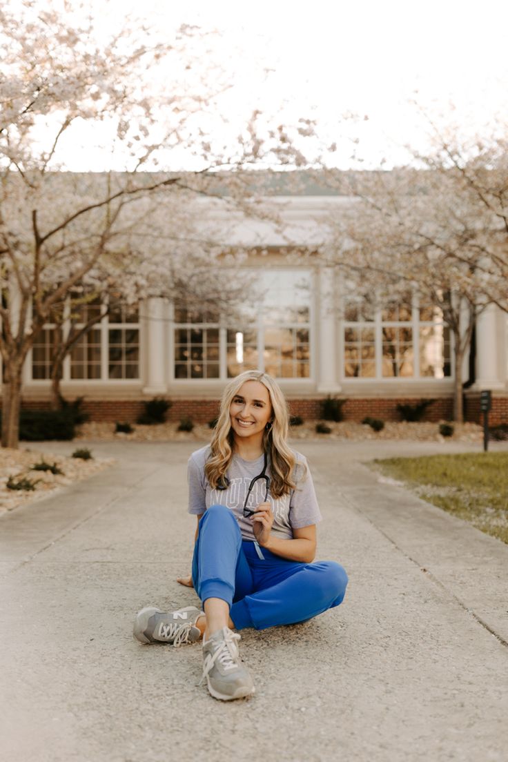 a woman sitting on the ground in front of a building