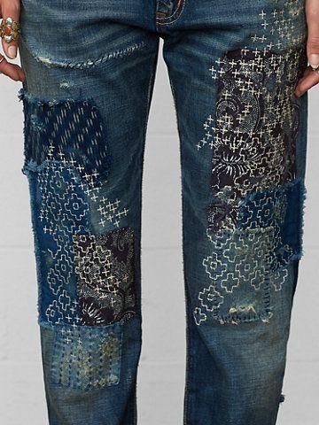 a pair of blue jeans with patches and holes on the side, both worn in different colors