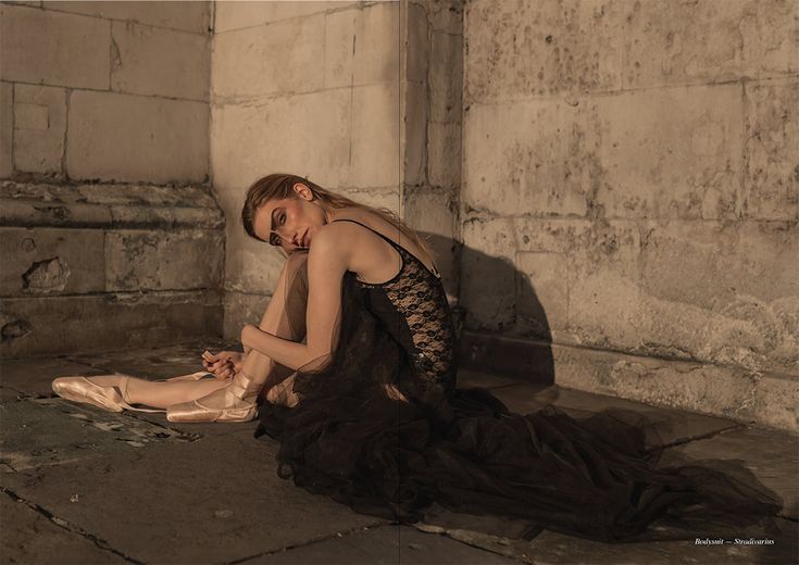 a woman is sitting on the ground with her feet up in front of her face