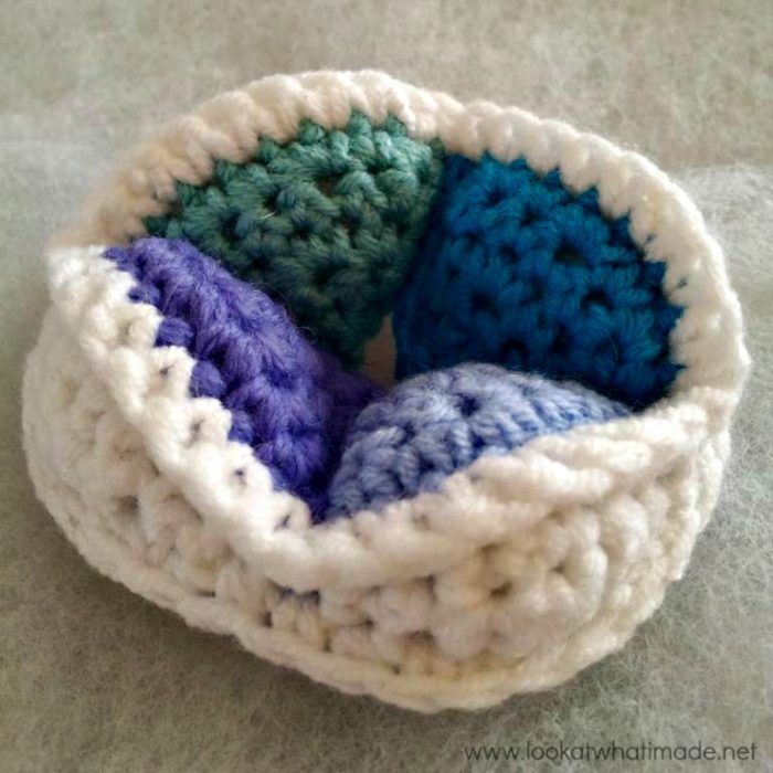 three crocheted bowls sitting on top of a white tablecloth covered floor next to each other