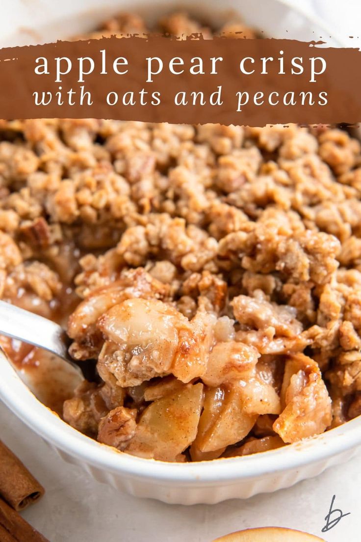 an apple crisp in a white bowl with cinnamon sticks