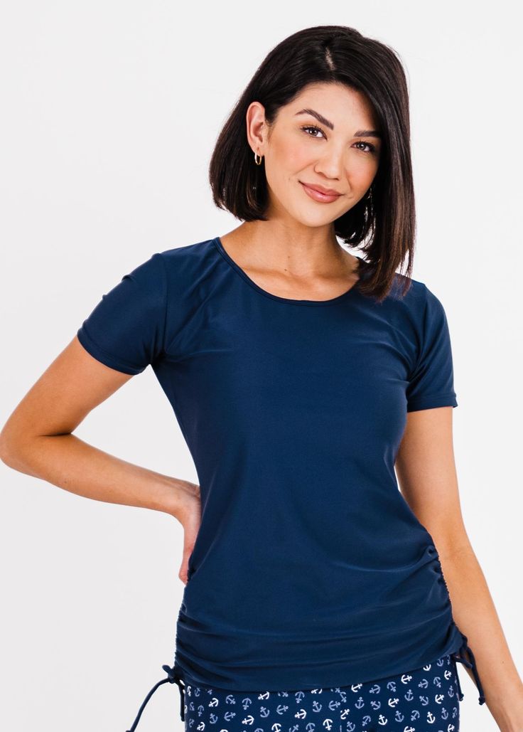 Adele Swim Top Fit & Sizing Tight Fit Sleeve Length 6.25” (Size S) Top Length 26.2” (Size S) If you are between sizes, or in doubt, please size up. Features Short Sleeve Round Neckline Does not feature a Built-in Bra Side ruching creates a flattering cinched look UPF50+ Sun Protection Quick Dry Care Rinse in cold water to wash off any chemicals, chlorinated water or saltwater Machine wash in cold water on gentle cycle Lay flat to dry in the shade Material 8 Blue Compression Tops Made Of Elastane, Blue Fitted T-shirt, Basic Fitted Moisture-wicking Tops, Basic Fitted Tops With Moisture-wicking, Fitted Navy Elastane Activewear, Fitted Solid Color Moisture-wicking T-shirt, Fitted Moisture-wicking Solid T-shirt, Fitted Solid Moisture-wicking T-shirt, Fitted Scoop Neck Activewear