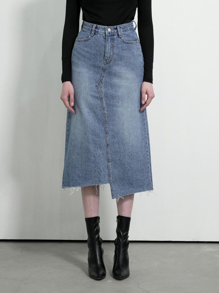 The skirt features a denim skirt with a distinctive split-front design, which gives it a modern and edgy look. The hem of the skirt is frayed, adding to its contemporary styling. It is fitted with a classic five-pocket configuration, with the pockets clearly visible on the front. The waistband includes belt loops and there's a central front closure, likely consisting of a button and a zipper. The skirt's wash has varying shades, giving it texture and visual interest.- The split-front and frayed hem are on-trend details that offer a fresh take on the traditional denim skirt.- The multiple shades within the wash provide the skirt with a dynamic appearance, highlighting its shape and design lines.- The incorporation of the five-pocket design and belt loops allows for practicality and versatil Chic Asymmetrical Medium Wash Denim Skirt, Chic High Waist Skirt With Frayed Hem, Dark Wash Asymmetrical Skirt With Frayed Hem, Spring Pencil Skirt With Frayed Hem, Fitted Denim Asymmetrical Skirt With Frayed Hem, Fitted Denim Pencil Skirt With Frayed Hem, Chic Asymmetrical Skirt In Medium Wash, Fitted Denim Skirt With Frayed Hem And Asymmetrical Shape, Fitted Denim Skirt With Frayed Hem And Asymmetrical Cut