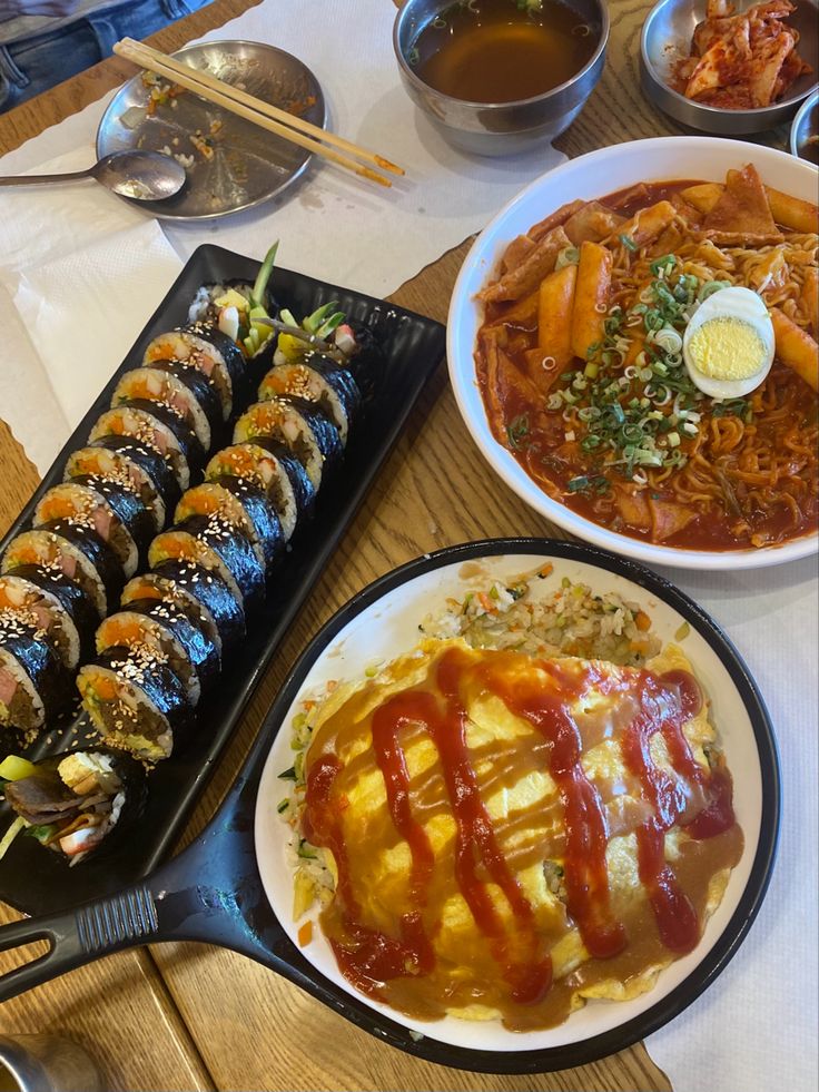 a table topped with plates of food and bowls of dipping sauce on top of them