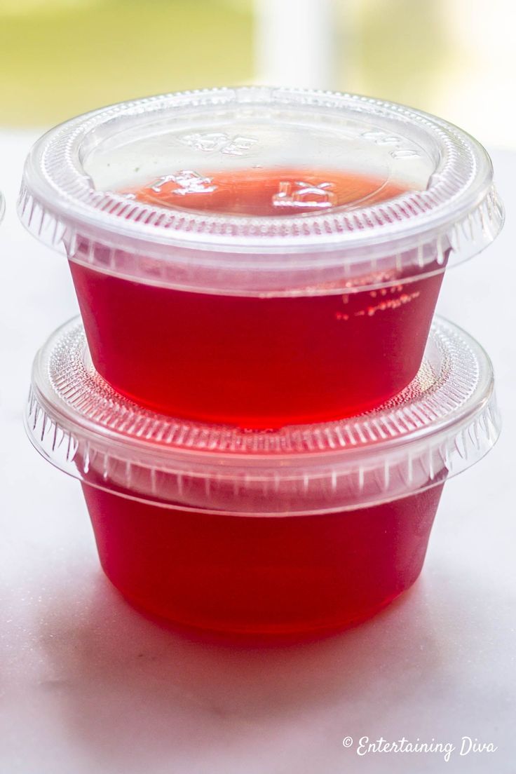 two plastic containers filled with liquid sitting on top of a table