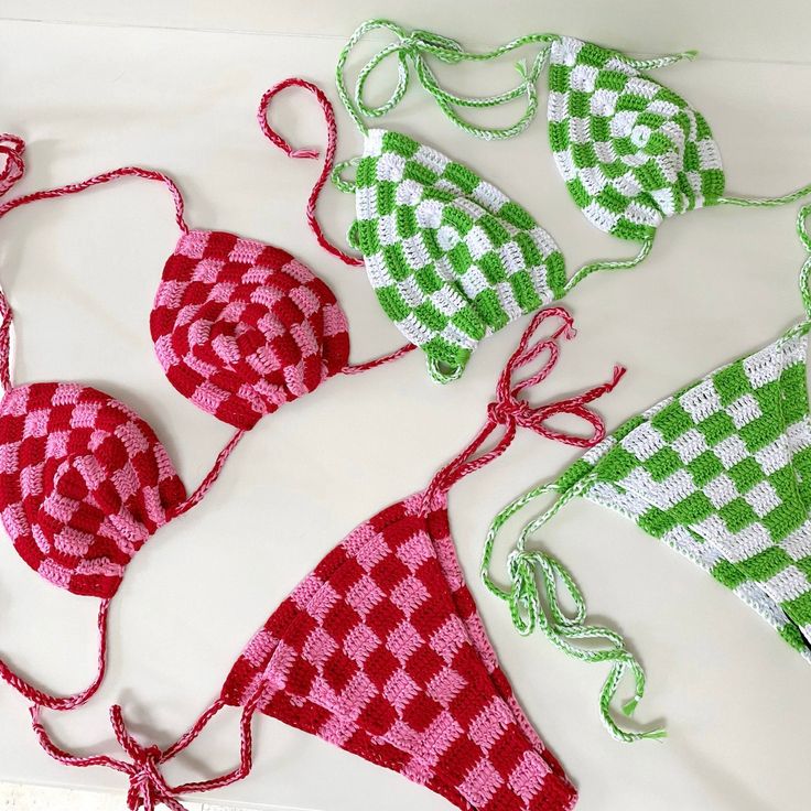 four bikinis made out of crochet are displayed on a white table top