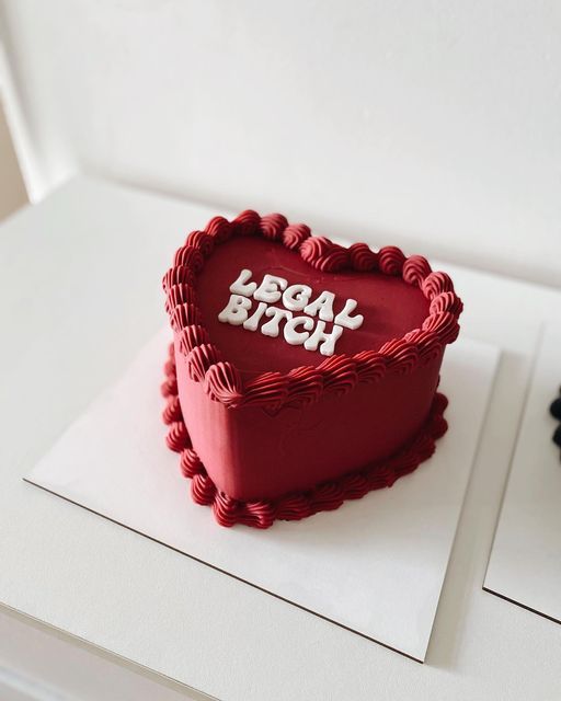 a red heart shaped cake sitting on top of a white table