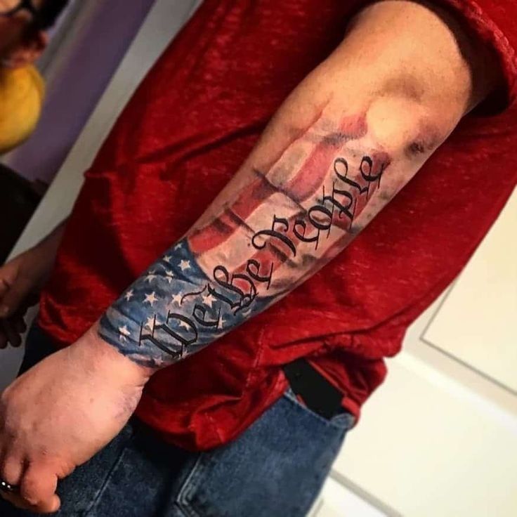 a man's arm with an american flag and words on it