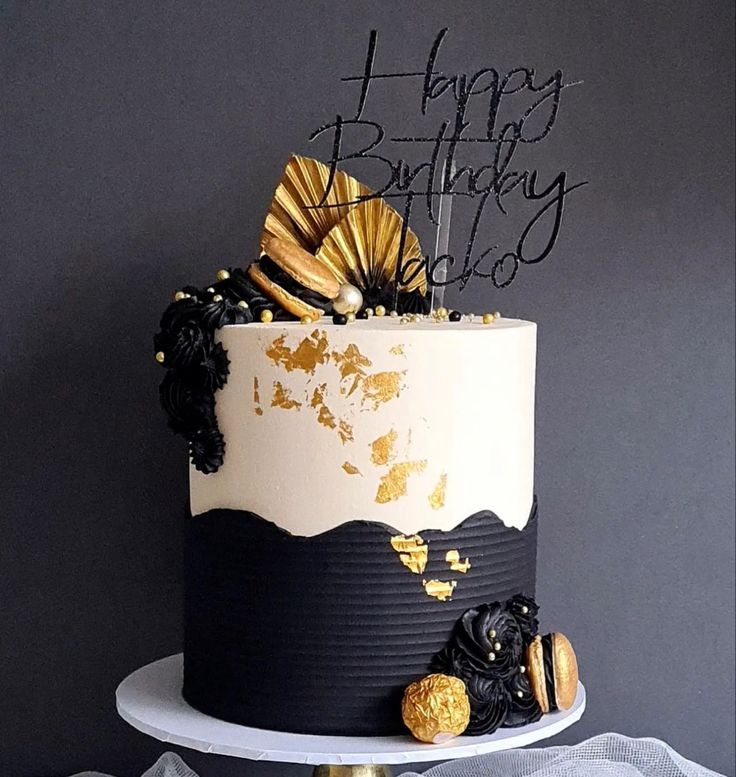 a black and white birthday cake with gold decorations