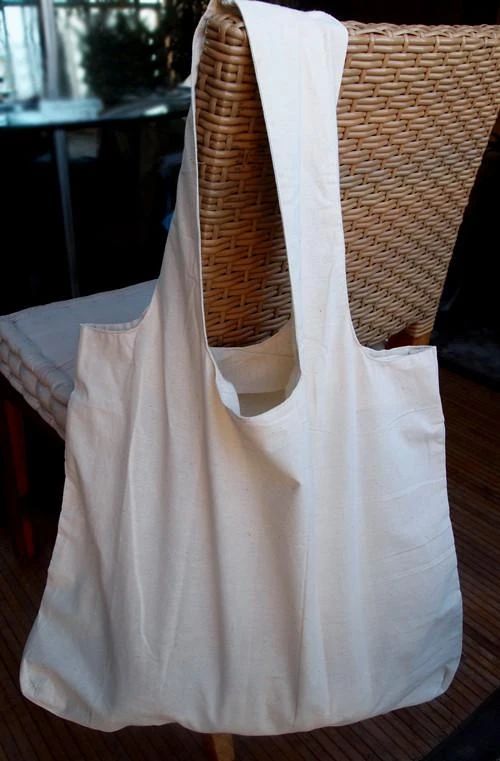 a white bag sitting on top of a wooden table next to a wicker chair