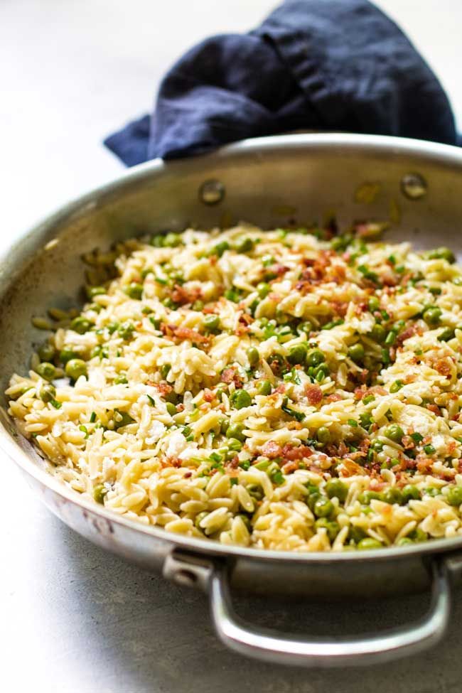 a pan filled with pasta and peas on top of a table