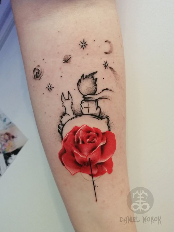 a tattoo with a rose on the arm and an image of a cat sitting on top of it