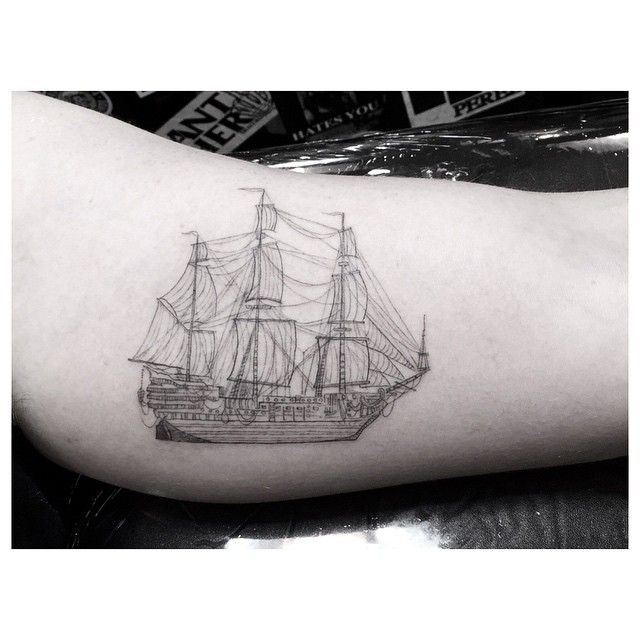 a black and white photo of a ship tattoo