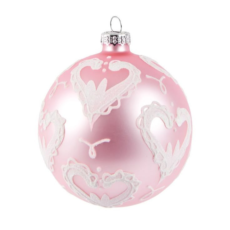 a pink christmas ornament with white lace on the top and heart shapes in the middle