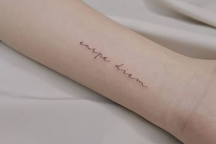 a person with a tattoo on their arm that says, love is patiently written in cursive writing