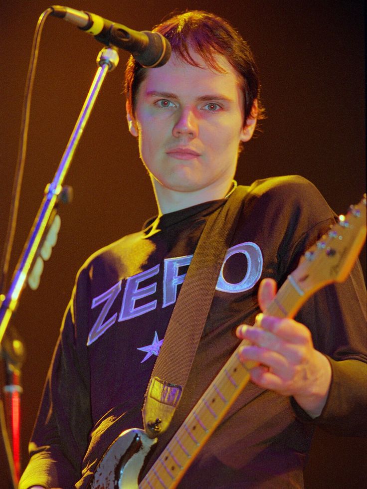 a young man playing an electric guitar on stage