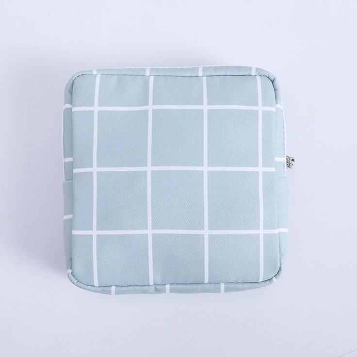 a blue and white checkered pillow on a white surface with a zippered closure