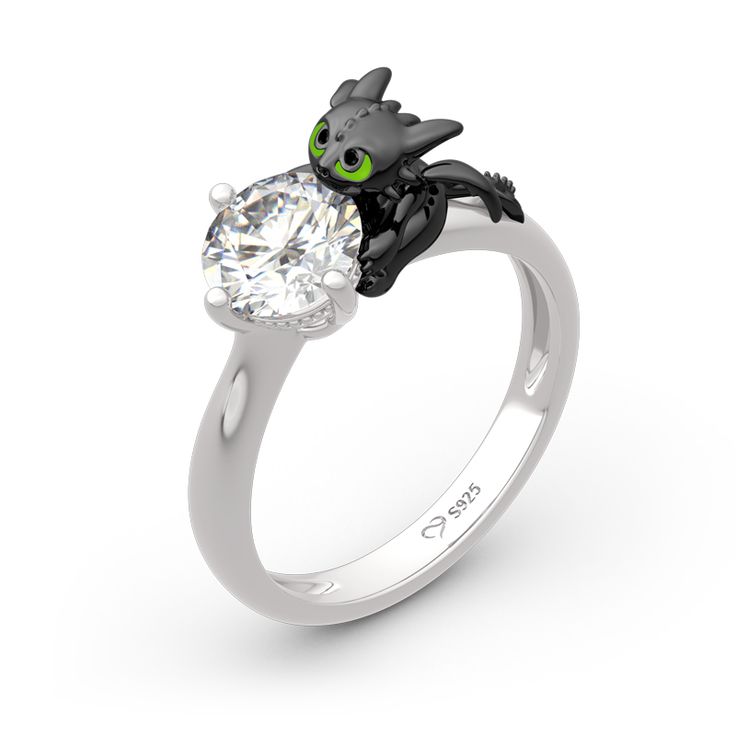 Playful, inquisitive and intelligent, this fictional dragon is indisputably special. You can't train a real dragon to wrap around your finger, but you can have this ring in Hug Me® collection. Beautifully handcrafted in sterling silver, this ring features a brilliant round cut stone hugged by a dragon, which is designed to be so lovely and super-cute. His 3D wings, ears and bright green eyes are captured in amazing detail as he on your finger. You will find more adorable and creative designs in our Hug Me® collection.Carat Weight: 2.5 ctStone Size: 7 mmStone Type: Jeulia® StoneNumber of Stones: 1 Stone Color: Diamond WhiteStone Shape: RoundCarat Weight: 0.3 ctStone Size: 0.8 mmStone Type: Jeulia® StoneNumber of Stones: 2 Stone Color: Fancy BlackStone Shape: RoundWeight: 4.8 gWidth: 2.8 mmH Cute Engagement Rings, Dragon Jewelry, Magical Jewelry, Toothless, Cute Rings, Pretty Rings, Fashion Ring, Hug Me, Fantasy Jewelry