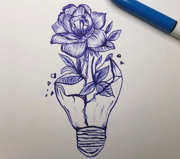 a pencil drawing of a light bulb with flowers on it and an ink pen next to it