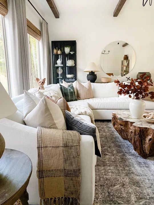 a living room filled with lots of furniture and pillows on top of a wooden table