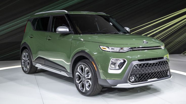 a green suv is on display at an auto show