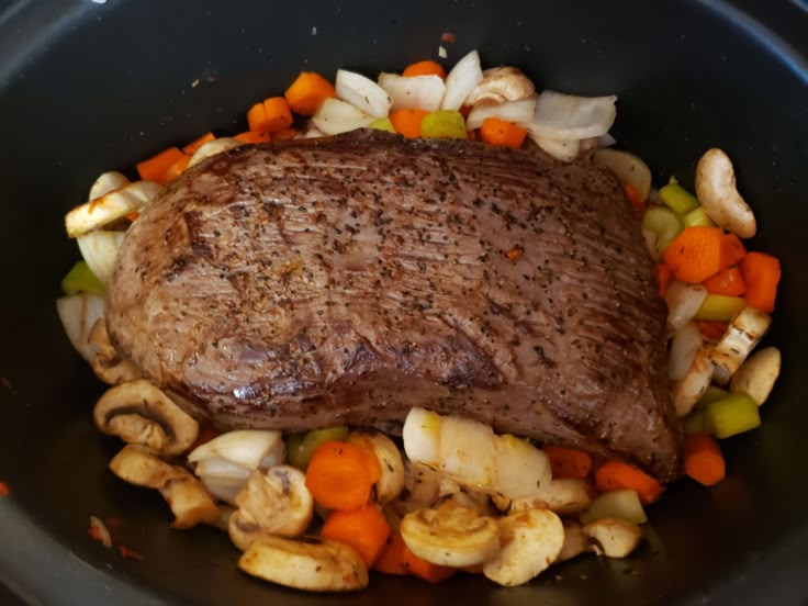 a steak and vegetables in a skillet ready to be cooked