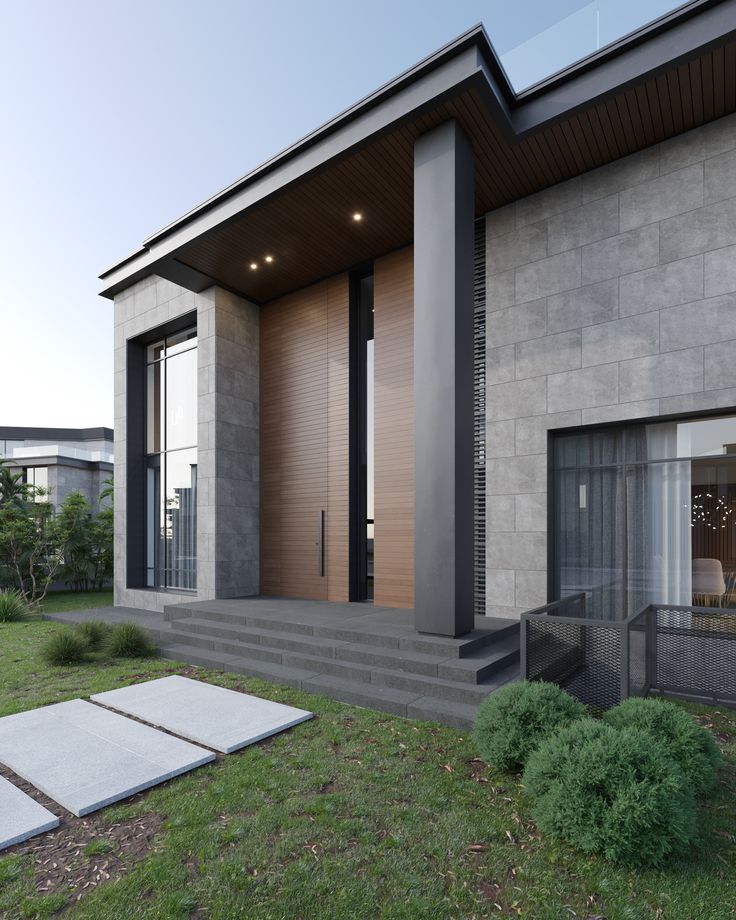 a modern house with large windows and concrete steps leading up to the front door area