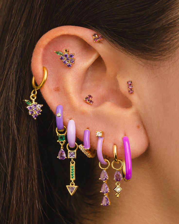 a close up of a person's ear with some piercings on it and an earring in the middle