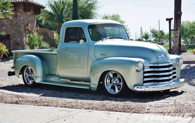 an old truck is parked on the side of the road