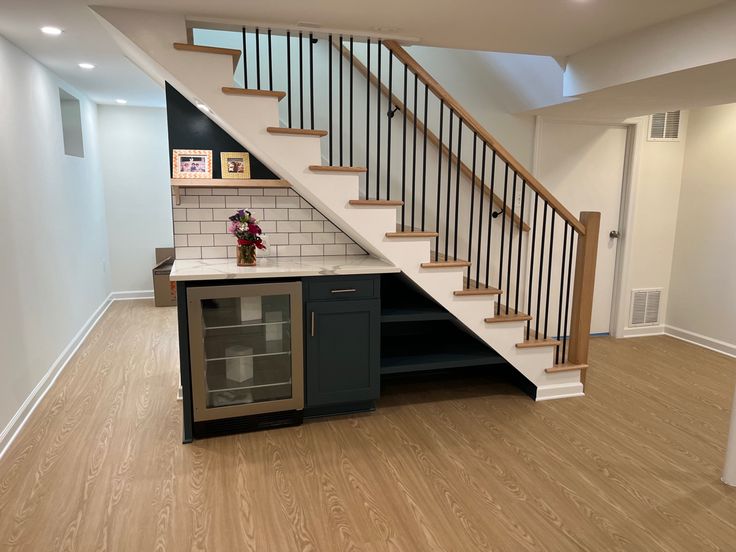 an empty kitchen under the stairs in a house