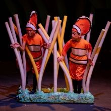 two men dressed as clowns are standing next to some sticks and poles in front of them