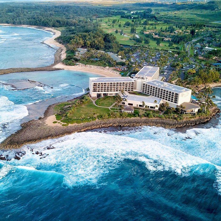 an aerial view of the resort and surrounding ocean with waves crashing in front of it