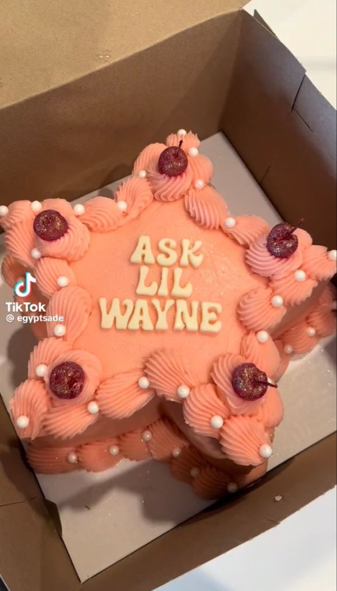 a pink cake in a box with the words ask lil wayne on it's side