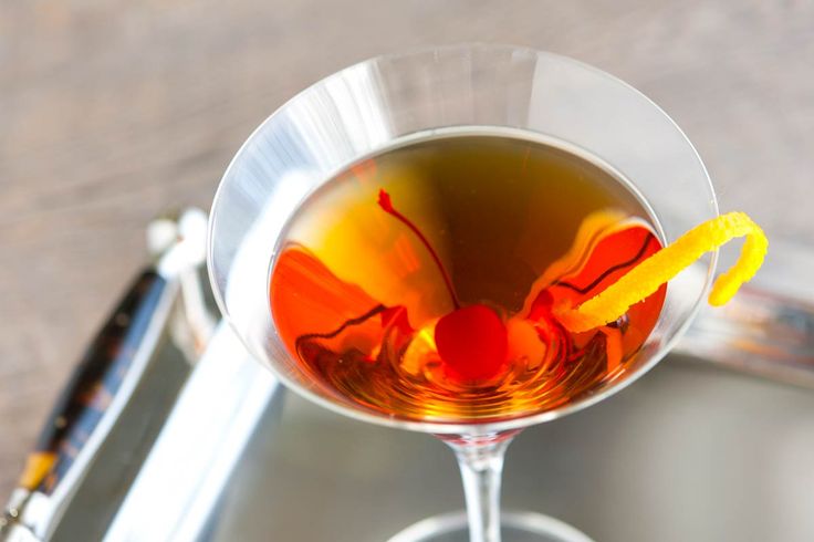 a glass filled with liquid sitting on top of a metal tray