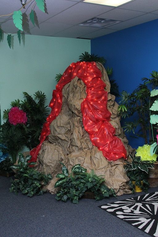 an office cubicle decorated with paper machs and fake trees, plants and flowers