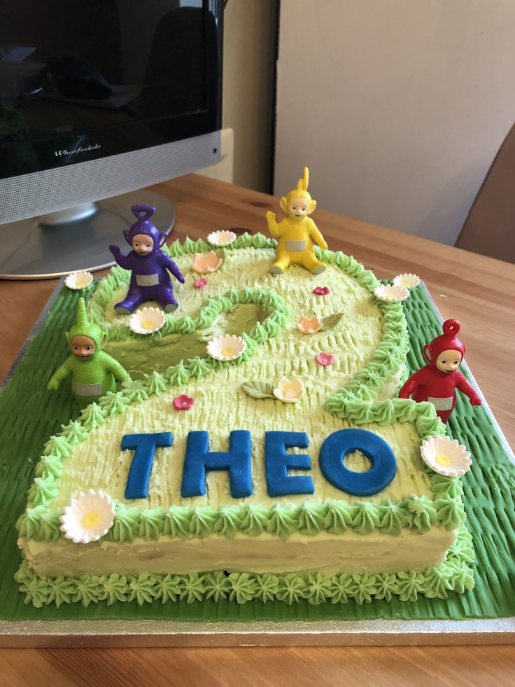 there is a cake that says theo on it and some small figurines