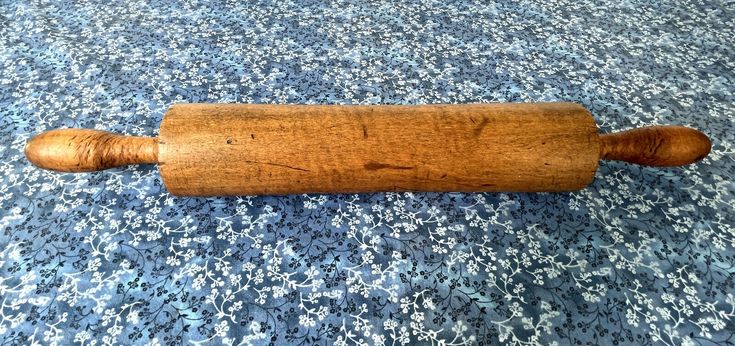 a wooden rolling pin laying on top of a blue carpet