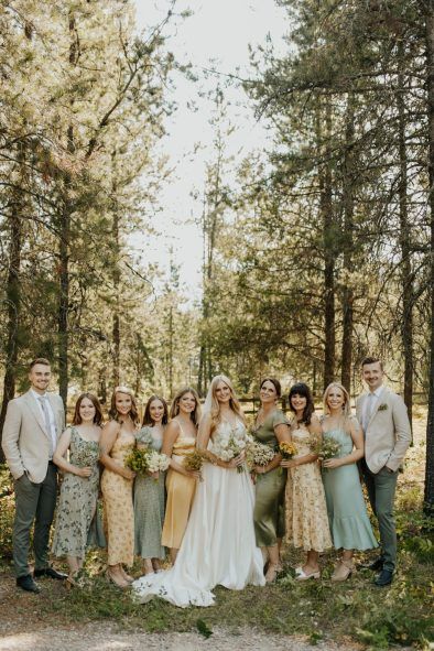 a group of people standing next to each other in front of some trees and grass