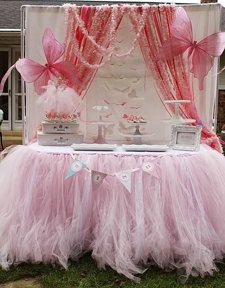 a table with pink tulle and decorations on it