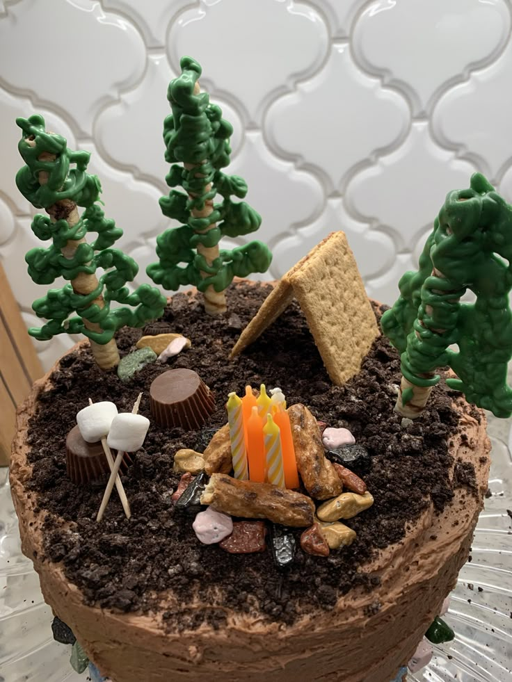 a cake decorated with trees, rocks and candy