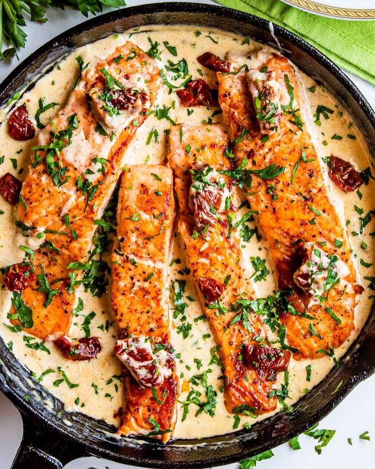 baked fish with cream sauce in a cast iron skillet, garnished with parsley