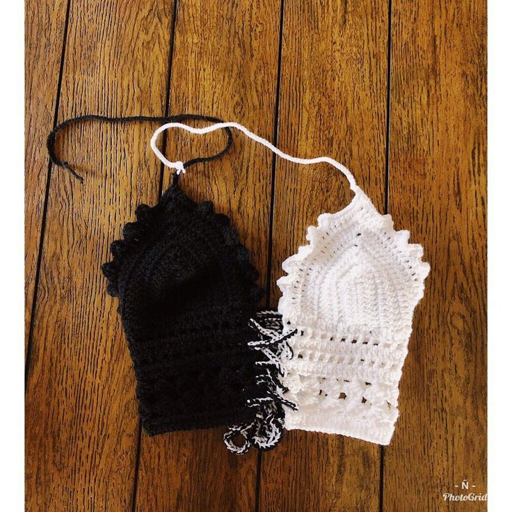 two knitted hats sitting on top of a wooden floor