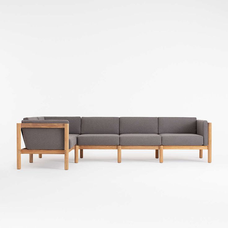 an l - shaped couch with two wooden legs and a green upholstered seat