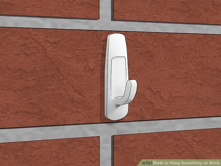 a brick wall with a door handle on it and an image of a red brick wall in the background