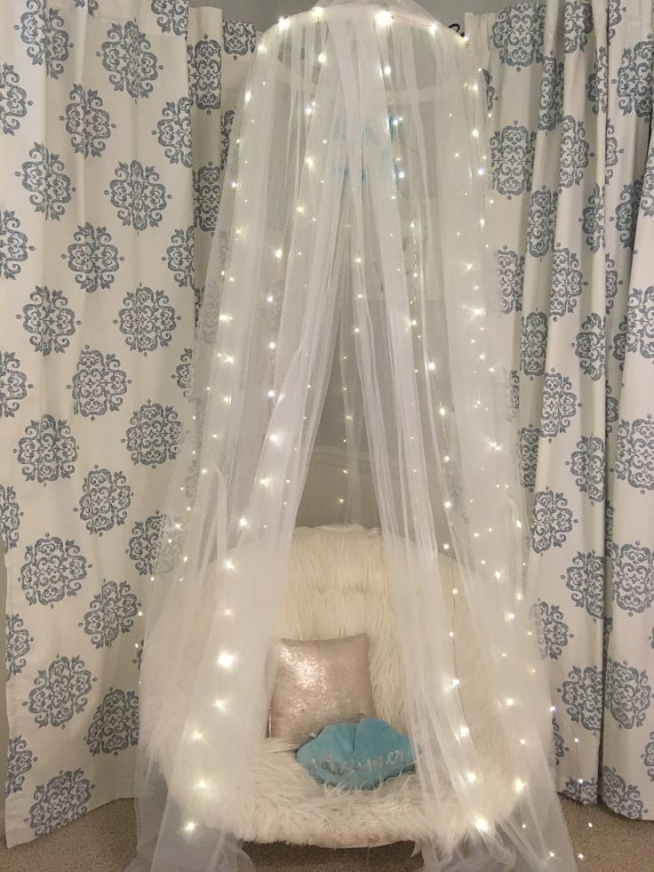 a canopy bed with white lights on it