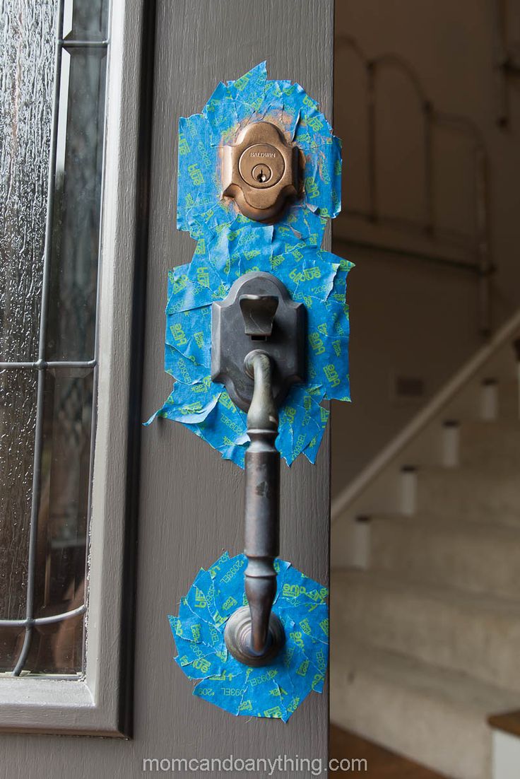 an old door handle has been torn off with blue paper and is next to a set of stairs