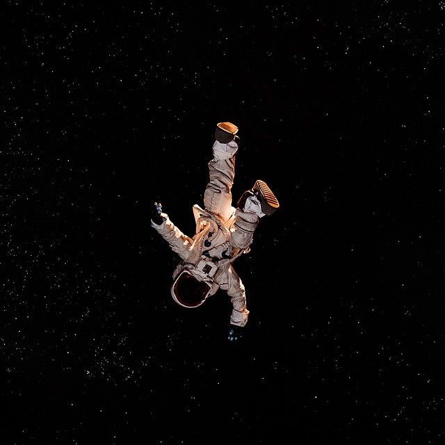 an astronaut floating in the air with his arms outstretched