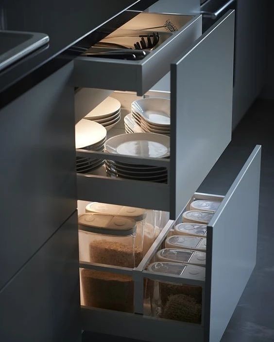 an open drawer in a kitchen filled with dishes